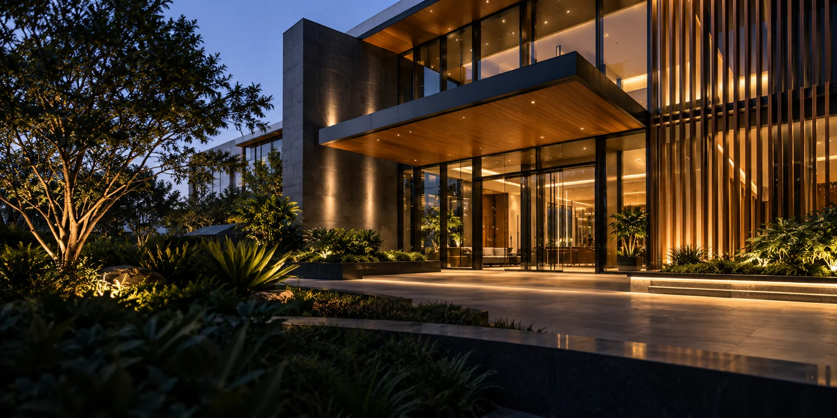 Illustrative contemporary commercial entrance with glass, timber details and landscaped greenery at dusk